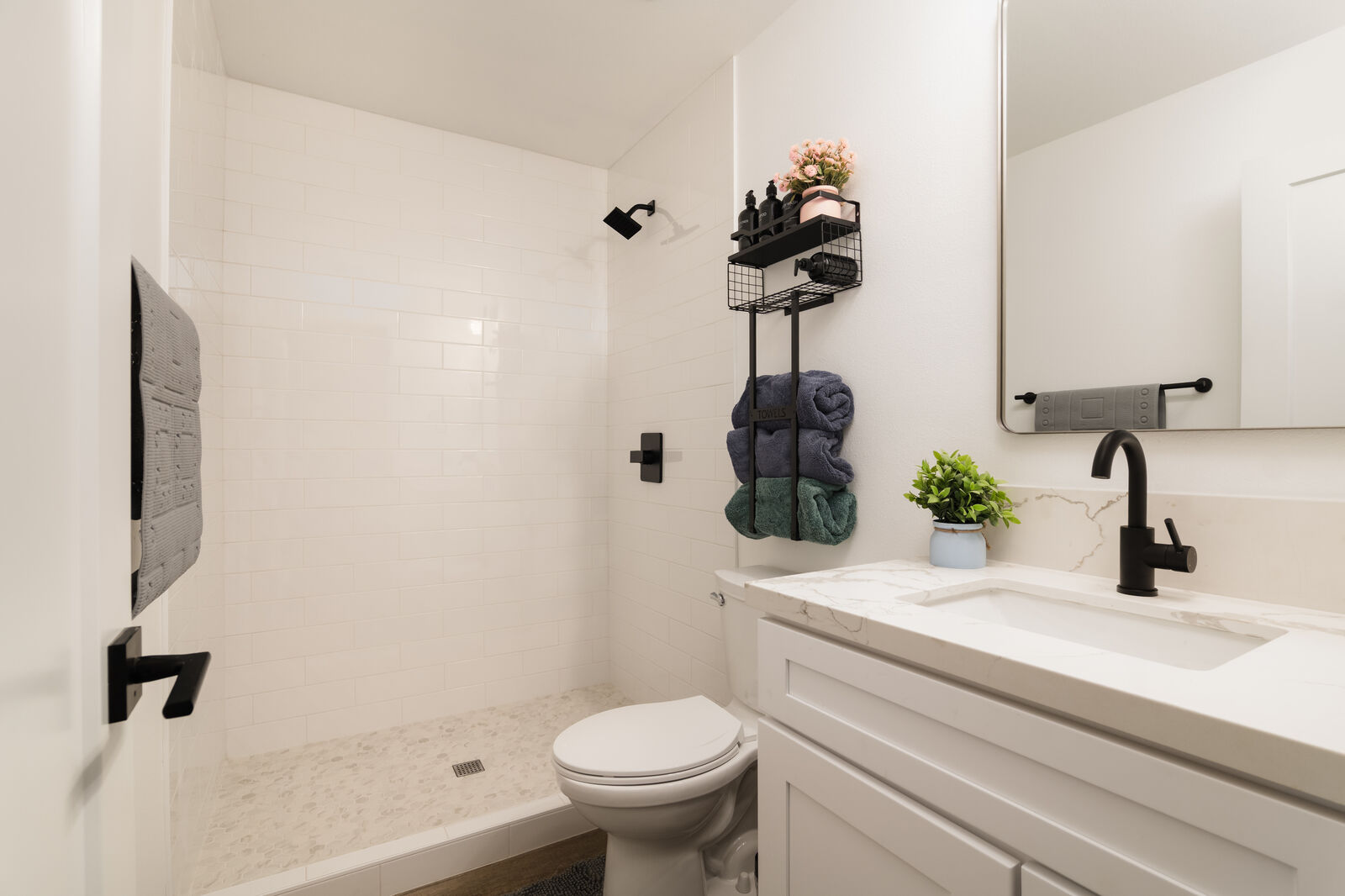 Modern bathroom — white tile, black fixtures