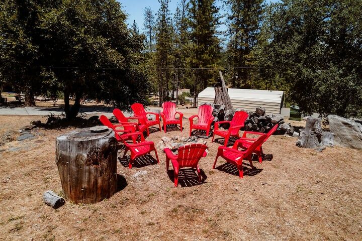 Red Adirondack chairs around fire pit