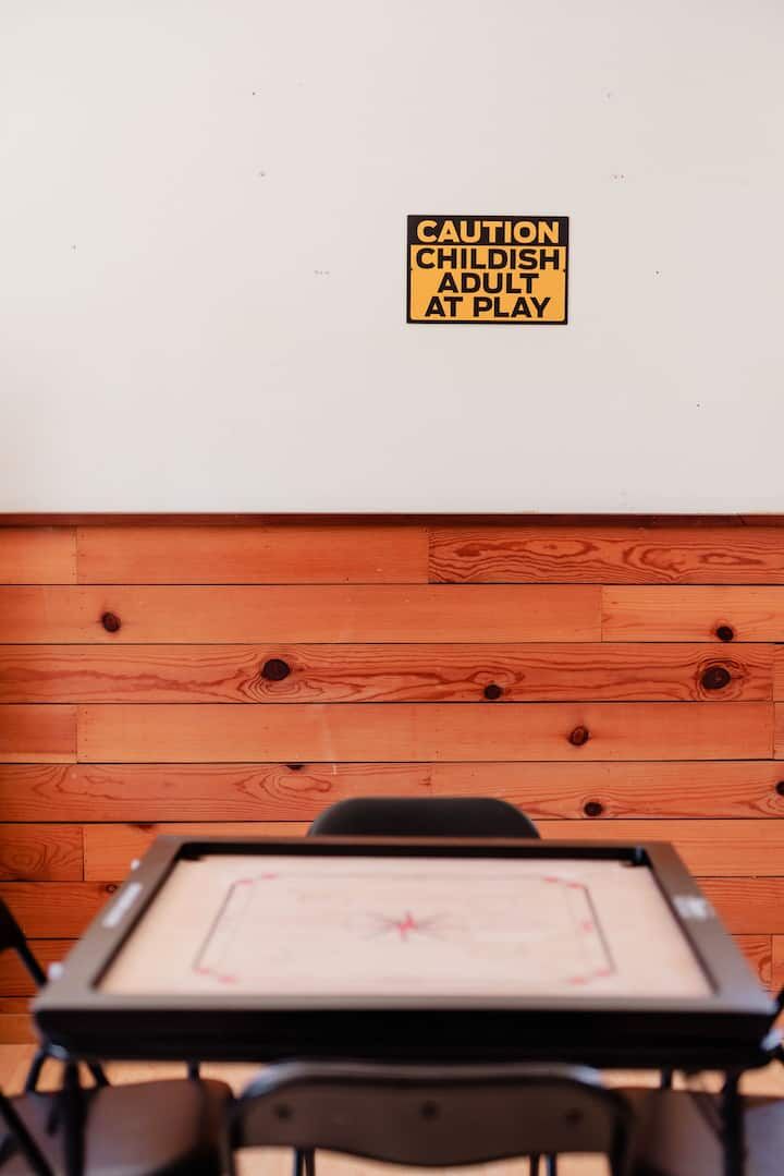 Carrom board with Caution Childish Adult sign